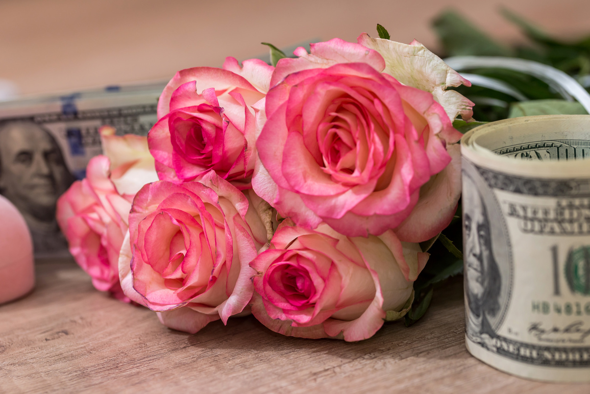 beautiful roses with money on desk